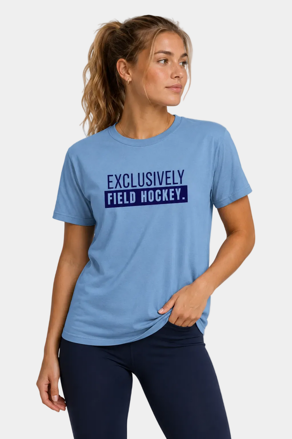 Woman wearing a blue t-shirt with 'Exclusively Field Hockey' text on a gray background