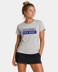 Woman wearing a gray t-shirt with 'Exclusively Field Hockey' text on a white background