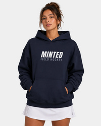Person wearing a navy hoodie with 'Minted Field Hockey' text on a plain background