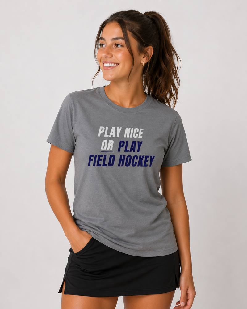 Woman wearing a gray t-shirt with 'Play Nice or Play Field Hockey' text on a plain background