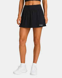 Field hockey player wearing black skort with exclusively field hockey logo embroidered on bottom left.