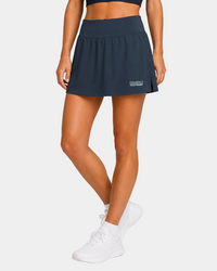 Field hockey player wearing navy skort with exclusively field hockey logo embroidered in white on bottom left.