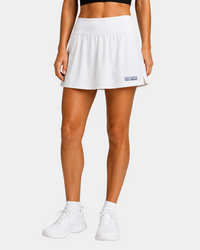 Field Hockey layer wearing white exclusively field hockey skort embroidered bottom left in blue.