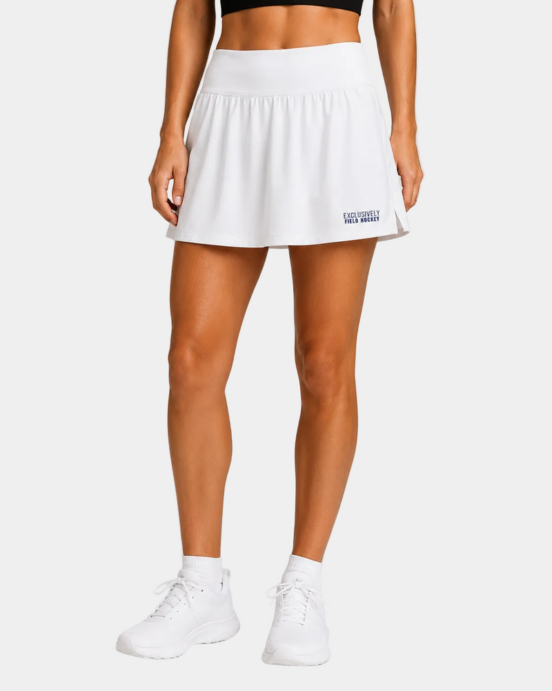 Field Hockey layer wearing white exclusively field hockey skort embroidered bottom left in blue.