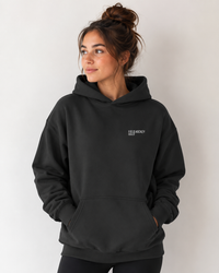 Girl wearing field hockey goalie hoodie with white embroidery text.