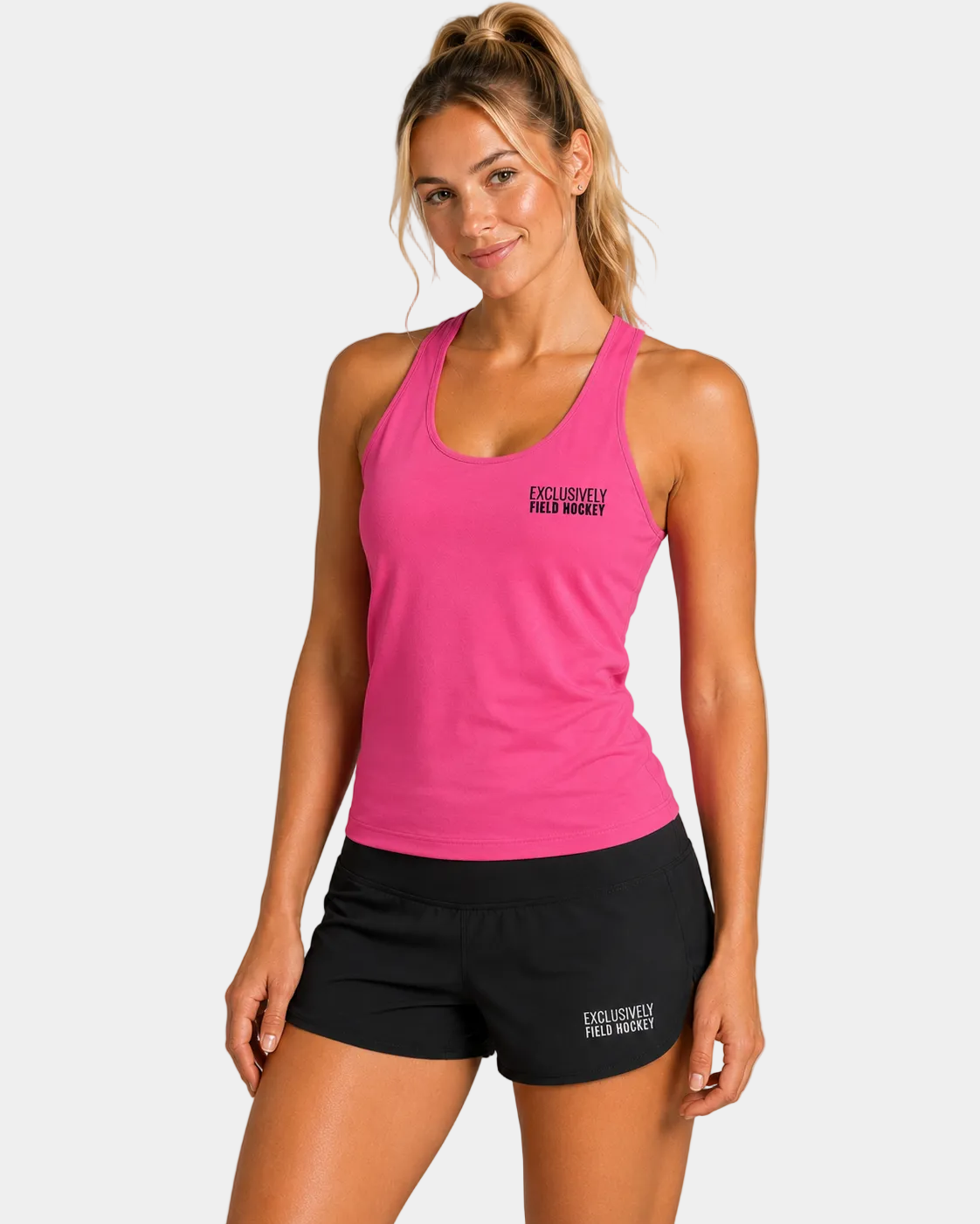 Women's field hockey racerback tank in Neon Pink featuring embroidered Exclusively Field Hockey logo. Lightweight moisture-wicking performance tank for field hockey forwards, midfielders, defenders, and athletes.